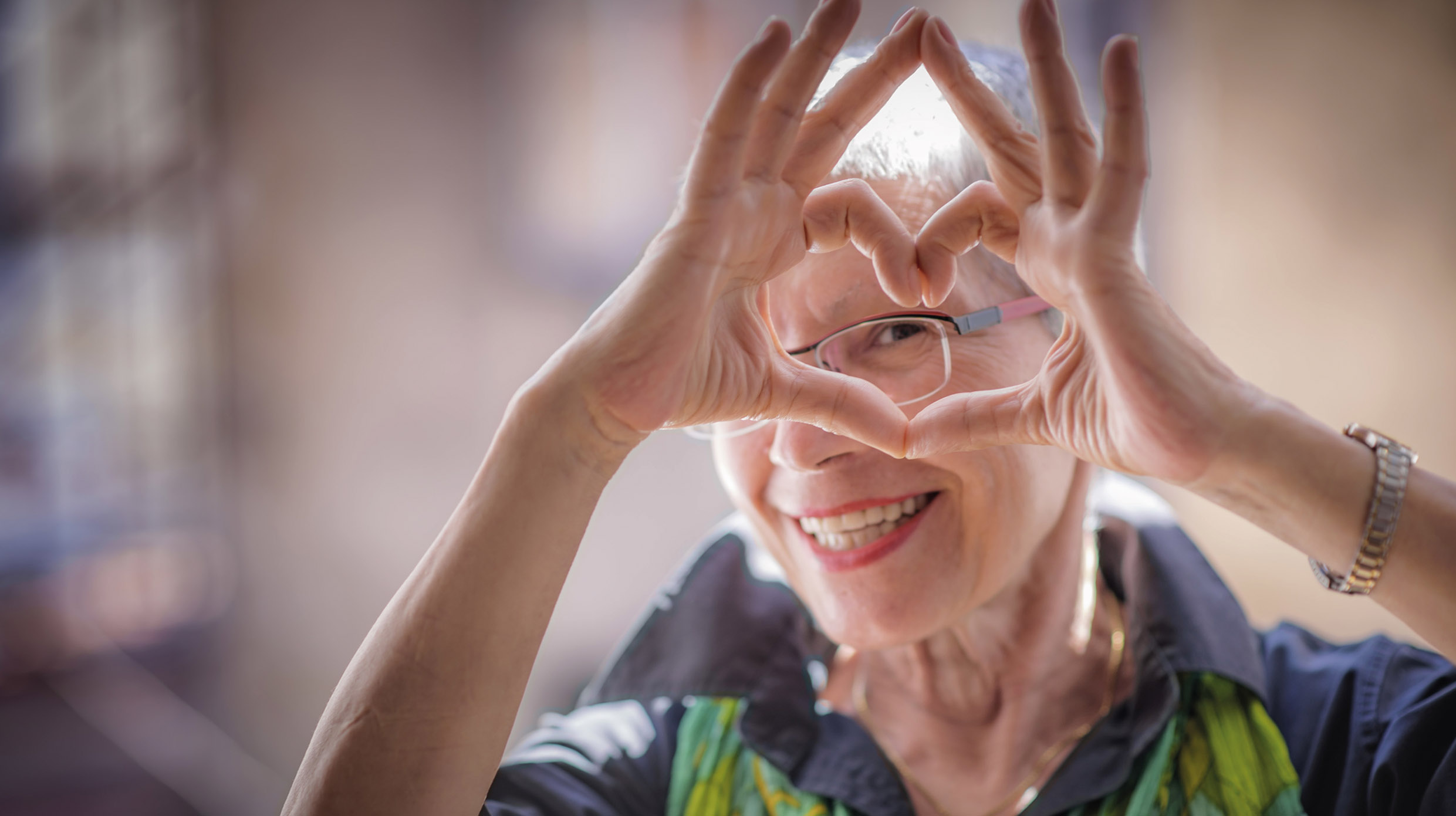 signora frontale con occhiali cuore con le dita