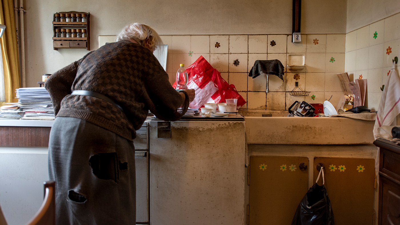 Une femme âgée pauvre dans sa cuisine.
